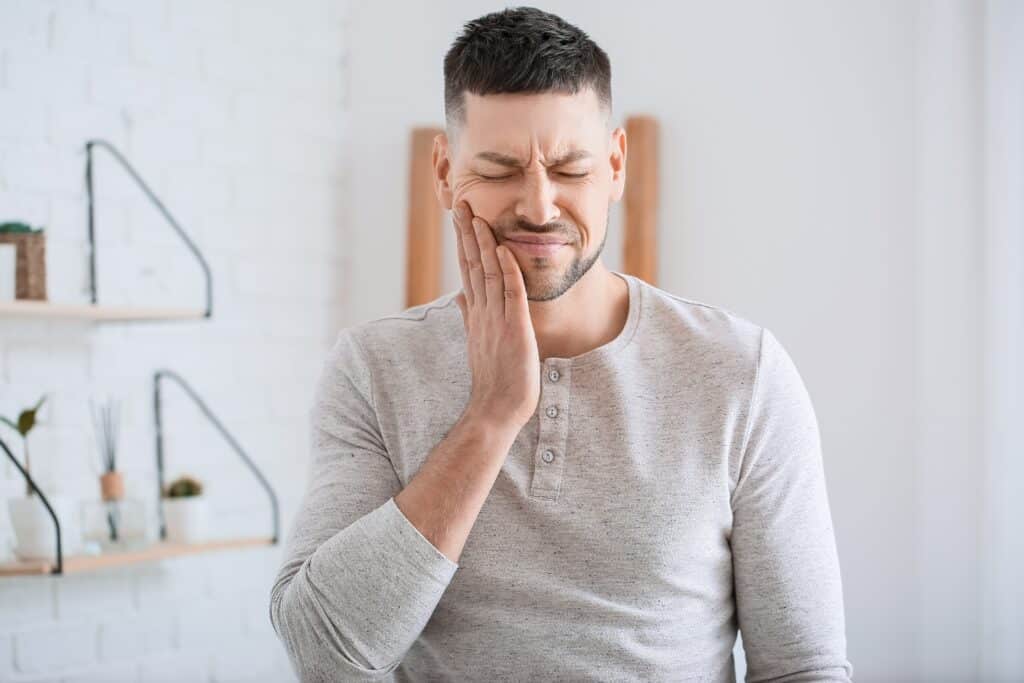 a young man surfing tooth pain