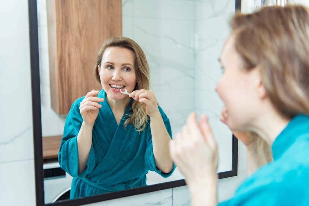 a young women flossing her teeth
