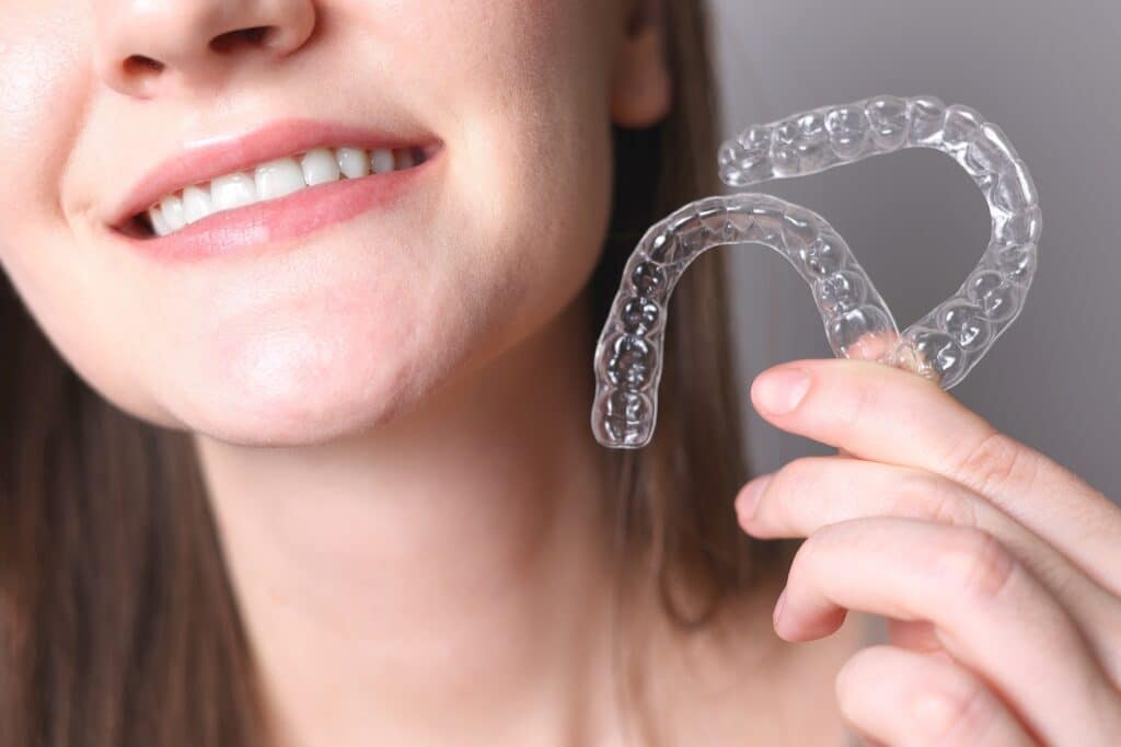 a girl showing teeth aligners