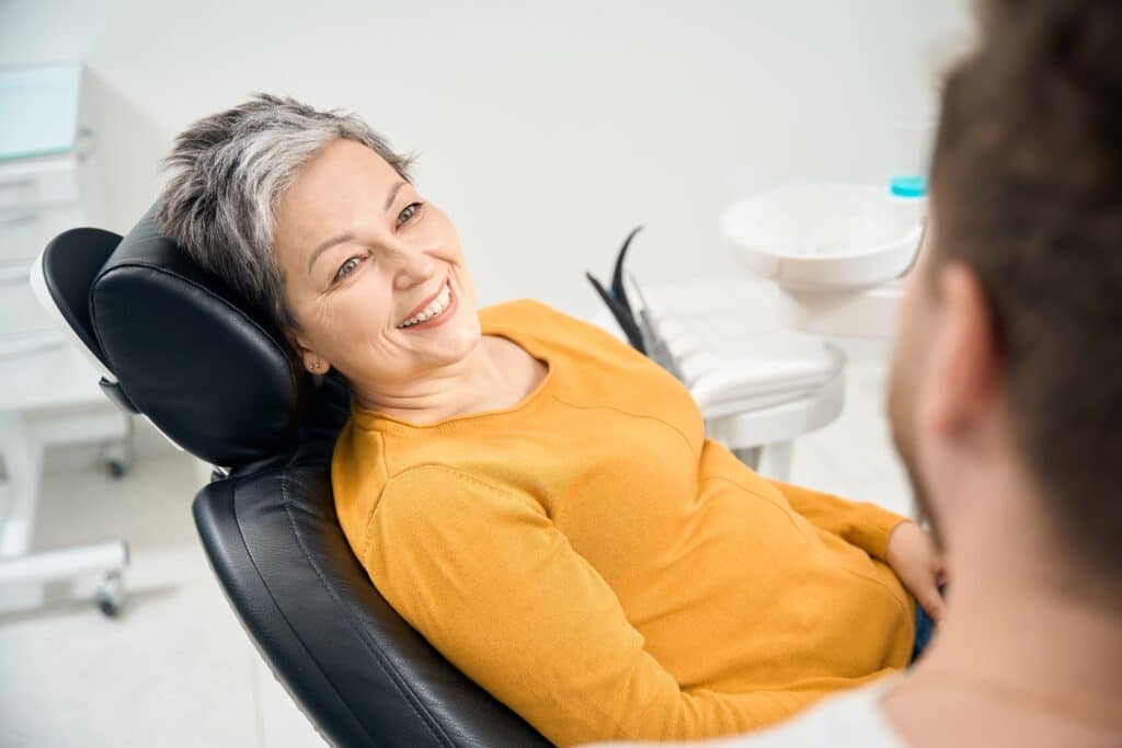 A older woman seating dentist chair