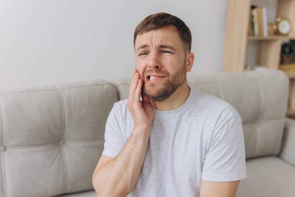 a young man surfing tooth pain